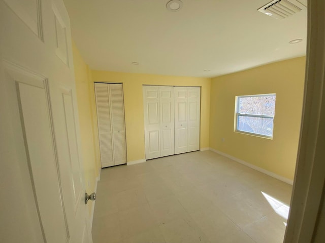 unfurnished bedroom with multiple closets