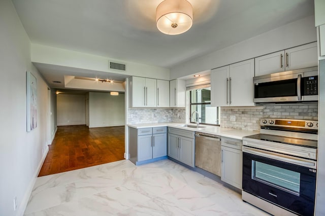 kitchen featuring stainless steel appliances, sink, and decorative backsplash