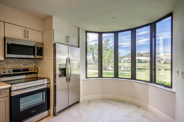 kitchen featuring white cabinetry, appliances with stainless steel finishes, and plenty of natural light