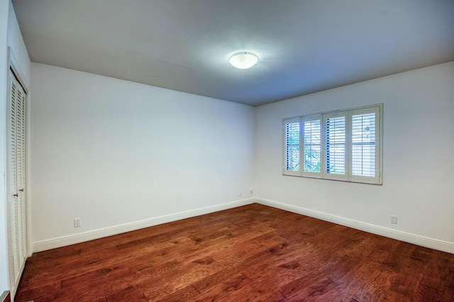 unfurnished bedroom with a closet and dark hardwood / wood-style floors