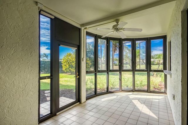 unfurnished sunroom featuring ceiling fan