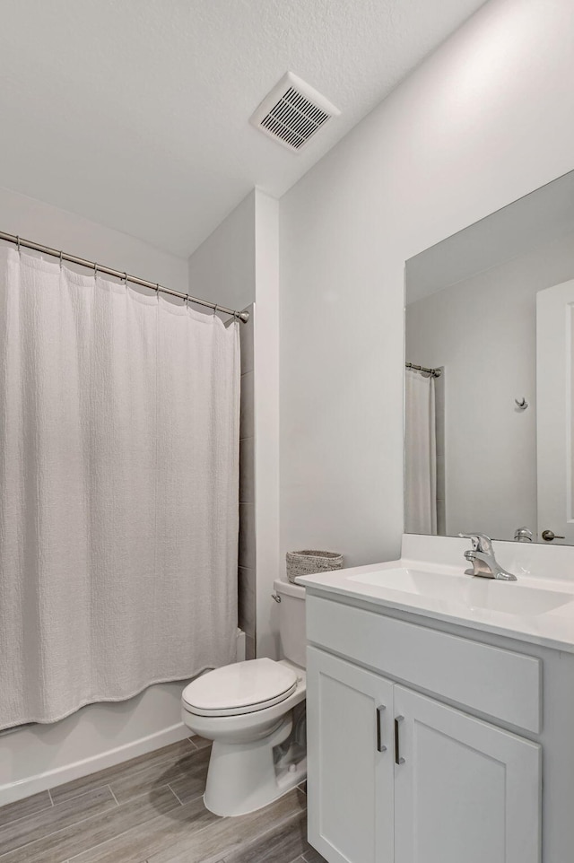 full bathroom with toilet, shower / tub combo, a textured ceiling, vanity, and hardwood / wood-style floors