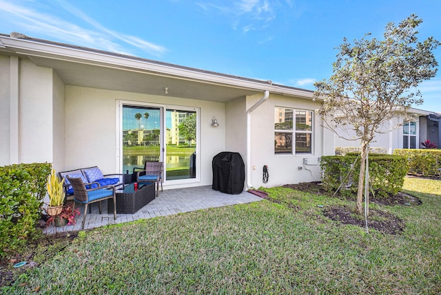 rear view of property featuring outdoor lounge area, a lawn, and a patio area