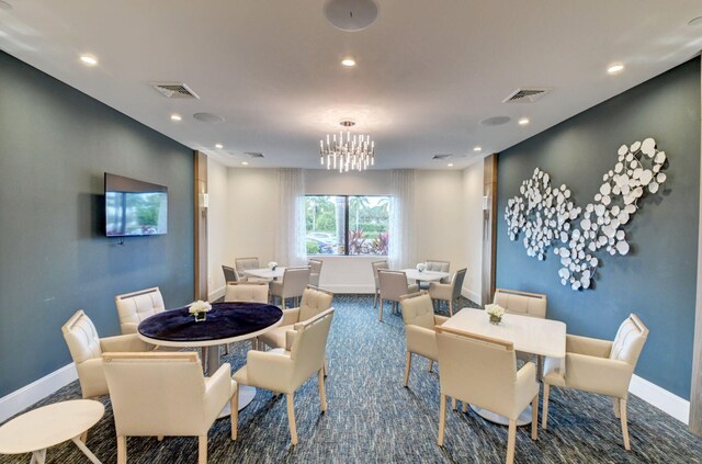 dining room with carpet floors and a chandelier