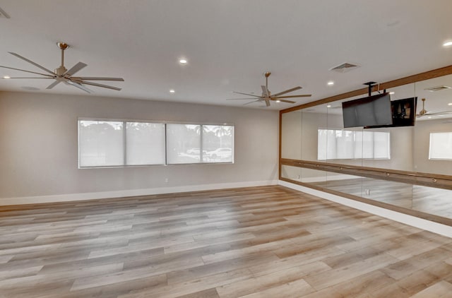 unfurnished room with a wealth of natural light, light hardwood / wood-style flooring, and ceiling fan