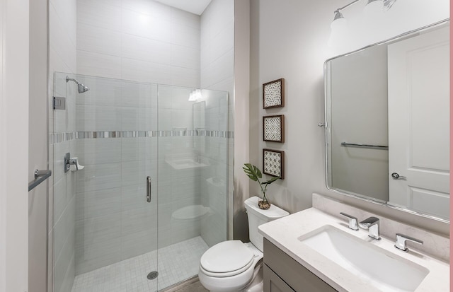 bathroom with vanity, toilet, and a shower with door