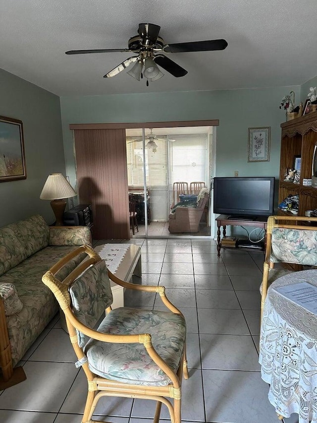 living room with a textured ceiling, ceiling fan, and tile patterned flooring