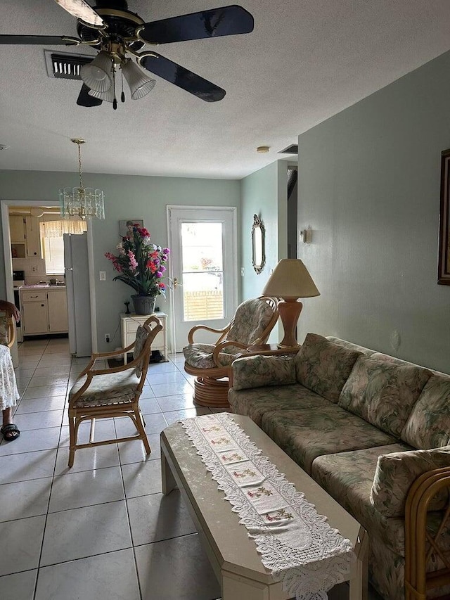 living room featuring ceiling fan, a textured ceiling, and light tile patterned flooring