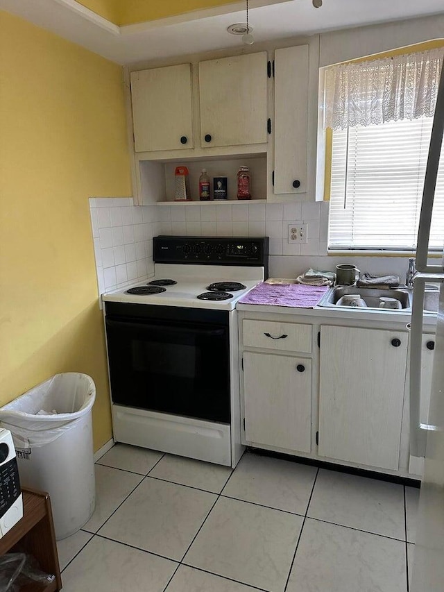 kitchen featuring light tile patterned floors, decorative backsplash, electric range, and sink