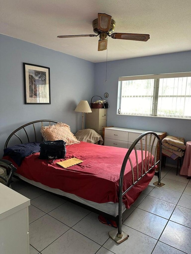 tiled bedroom featuring ceiling fan