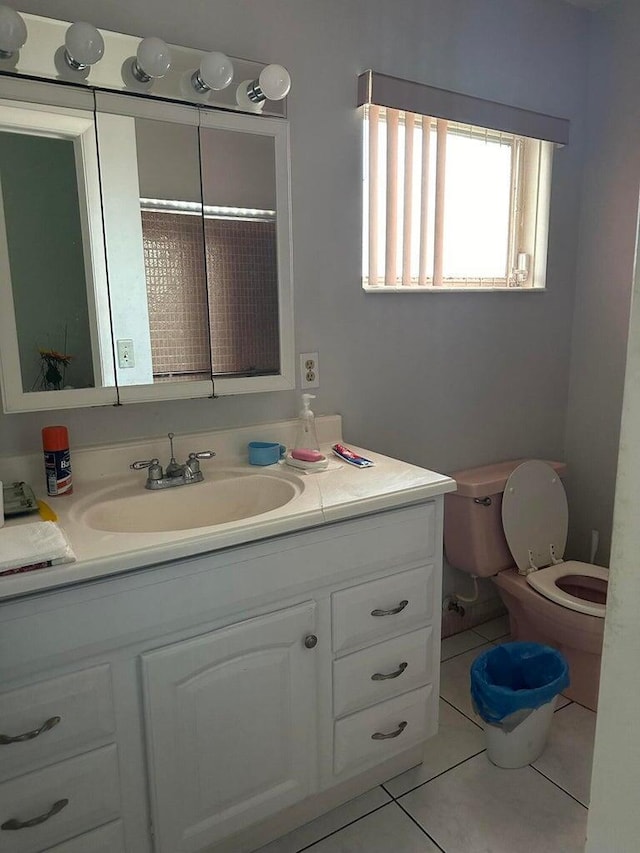 bathroom with toilet, vanity, and tile patterned flooring