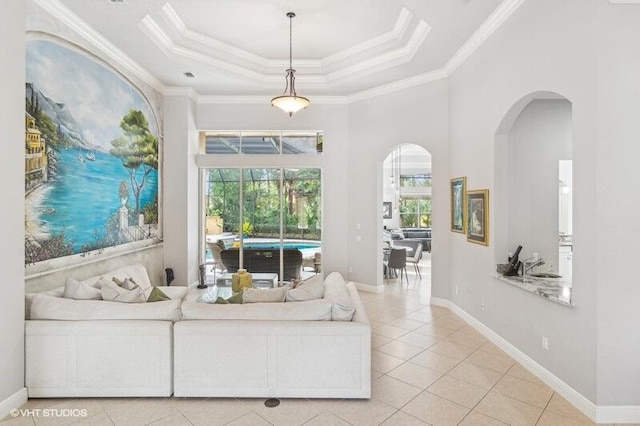 tiled living room with a high ceiling, crown molding, and a tray ceiling