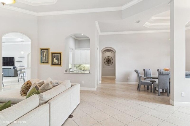 living room featuring ornamental molding, light tile patterned floors, and a tray ceiling