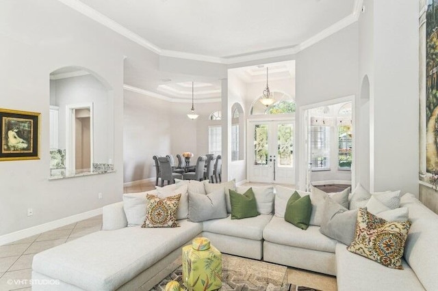 tiled living room featuring crown molding, french doors, and a towering ceiling