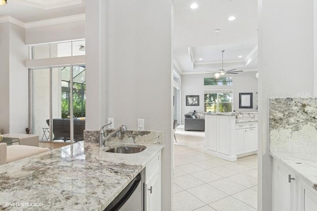 kitchen with sink, light stone counters, crown molding, a wealth of natural light, and white cabinets