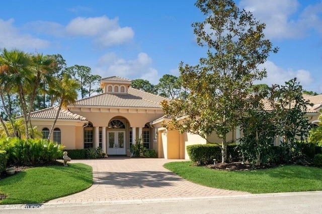 mediterranean / spanish-style home featuring french doors and a front yard