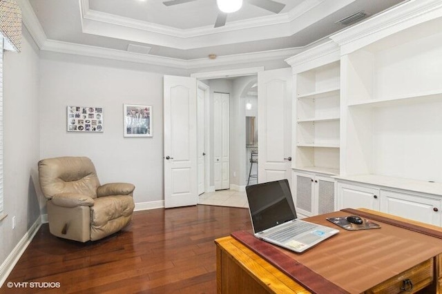 office area featuring hardwood / wood-style floors, crown molding, a raised ceiling, and ceiling fan