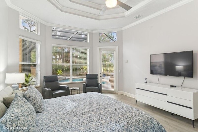 bedroom with crown molding, a raised ceiling, access to outside, and hardwood / wood-style flooring