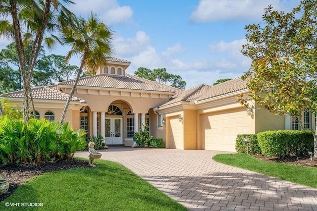 mediterranean / spanish house featuring a garage and french doors