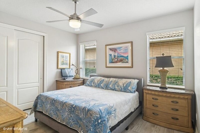 bedroom with wood-type flooring, ceiling fan, and a closet