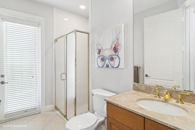 bathroom with tile patterned floors, vanity, toilet, and an enclosed shower