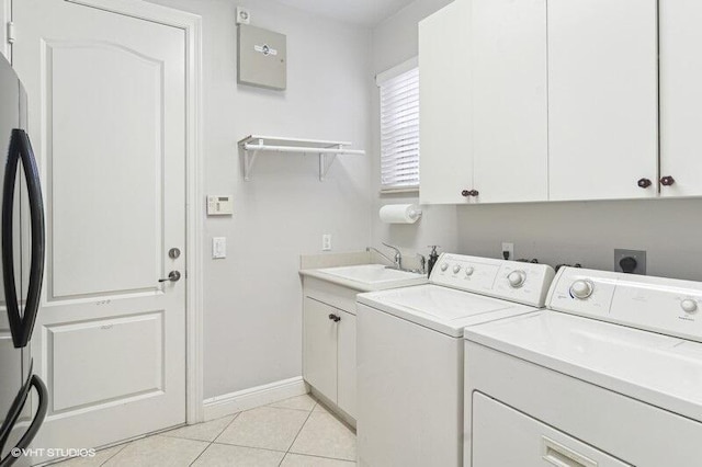 washroom featuring cabinets, light tile patterned floors, sink, and washing machine and clothes dryer