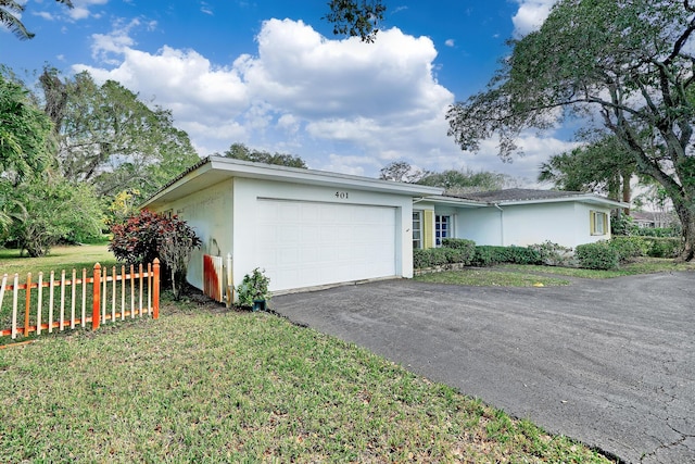 single story home featuring a garage and a front lawn