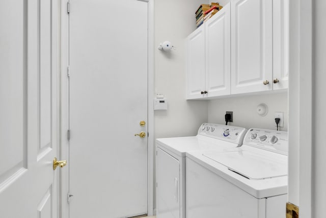 washroom with cabinets and washing machine and clothes dryer