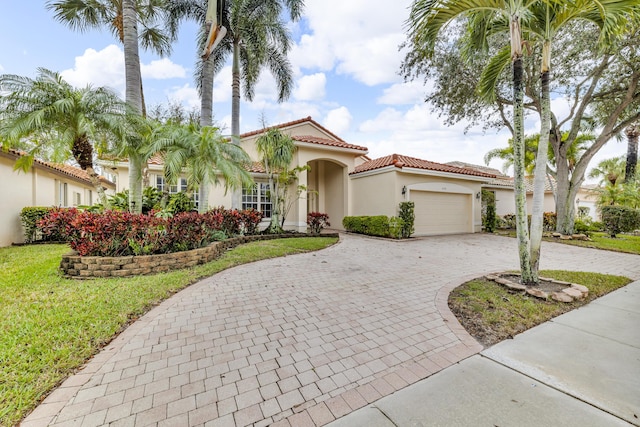 mediterranean / spanish-style house featuring a garage and a front lawn