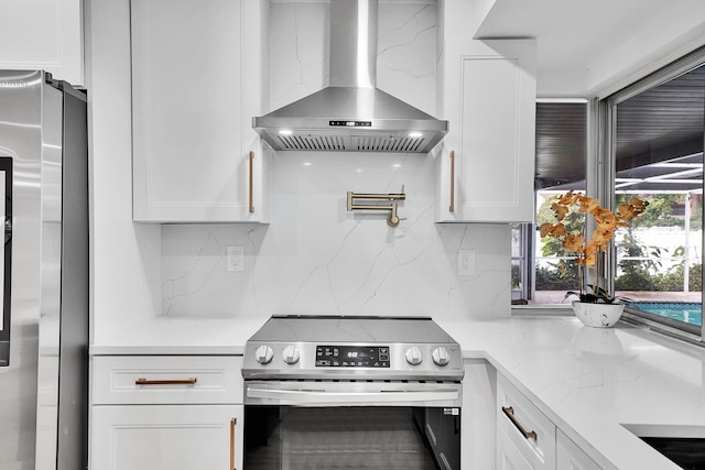 kitchen featuring ventilation hood, appliances with stainless steel finishes, and white cabinetry