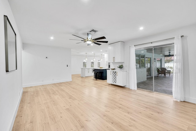 unfurnished living room with ceiling fan and light hardwood / wood-style flooring