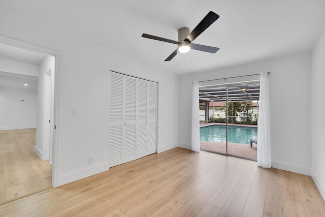 unfurnished bedroom featuring ceiling fan, access to exterior, and light hardwood / wood-style flooring