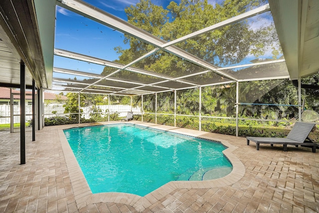 view of swimming pool with a patio area and glass enclosure