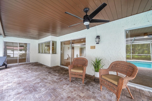 sunroom featuring ceiling fan, wooden ceiling, and a healthy amount of sunlight