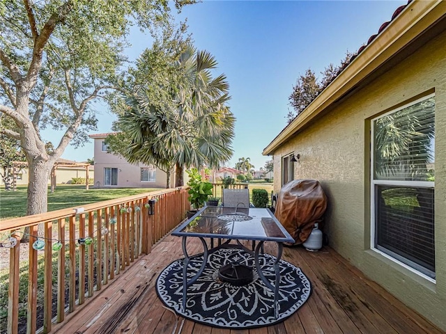 wooden terrace featuring a lawn and grilling area