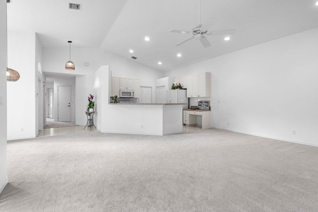 unfurnished living room with ceiling fan, high vaulted ceiling, and light carpet