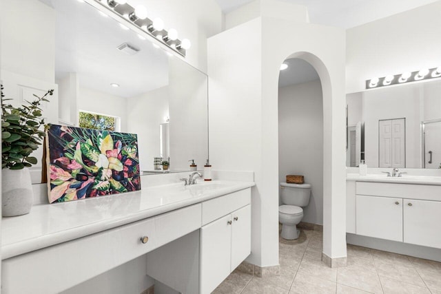 bathroom with toilet, vanity, and tile patterned flooring