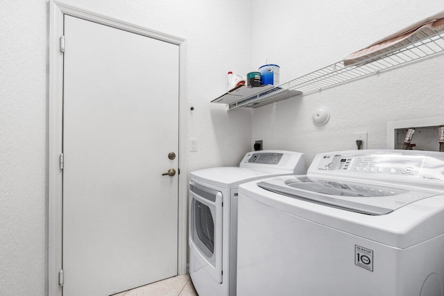 laundry area featuring light tile patterned floors and separate washer and dryer