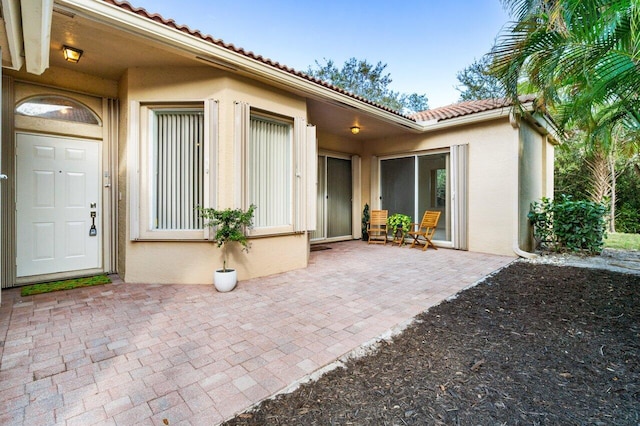 view of exterior entry with a patio