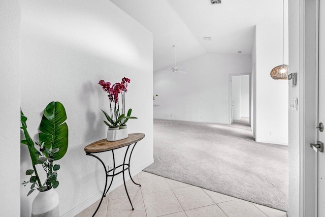 corridor with light tile patterned floors and vaulted ceiling