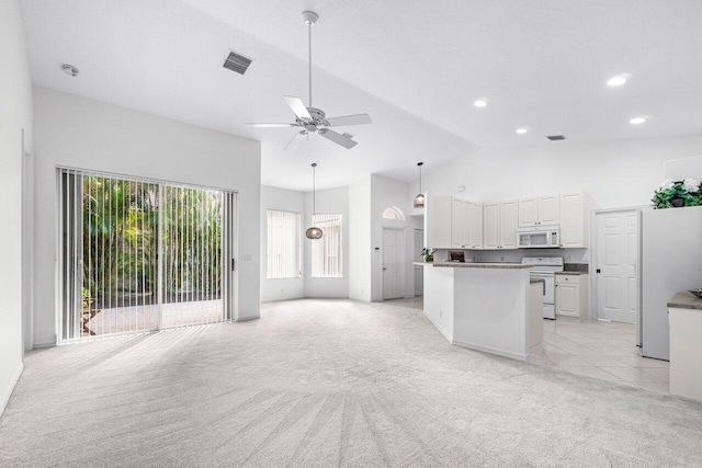 interior space featuring white cabinets, white appliances, light colored carpet, and plenty of natural light