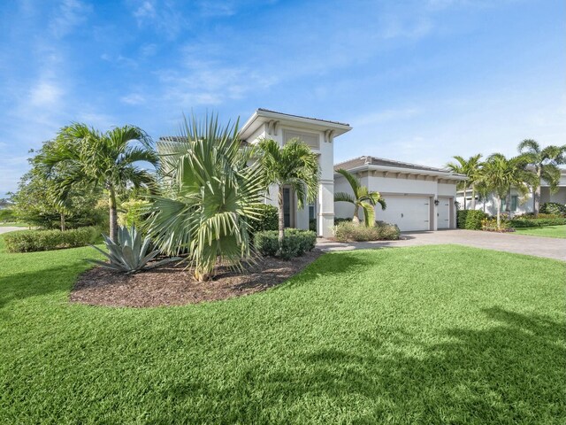4853 SW Millbrook Ln, Stuart, FL 34997 - view of front facade featuring a front lawn, concrete driveway, an attached garage, and stucco siding
