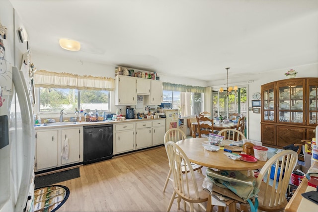 kitchen with decorative light fixtures, white refrigerator with ice dispenser, black dishwasher, sink, and light wood-type flooring