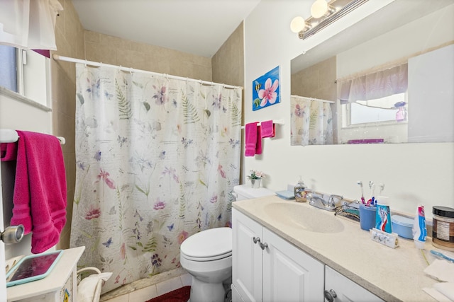 bathroom featuring toilet, vanity, a shower with curtain, and tile patterned floors