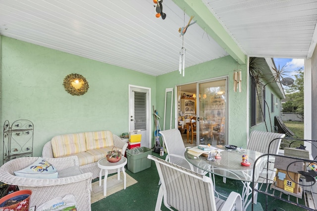 sunroom / solarium featuring beam ceiling