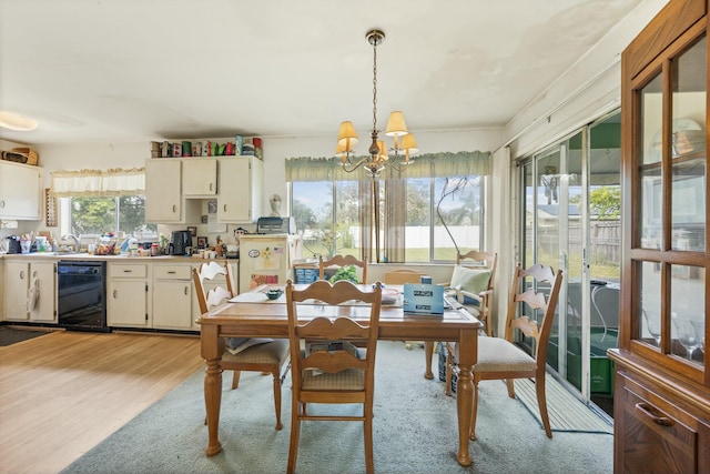 dining area with light wood-type flooring, sink, and a chandelier