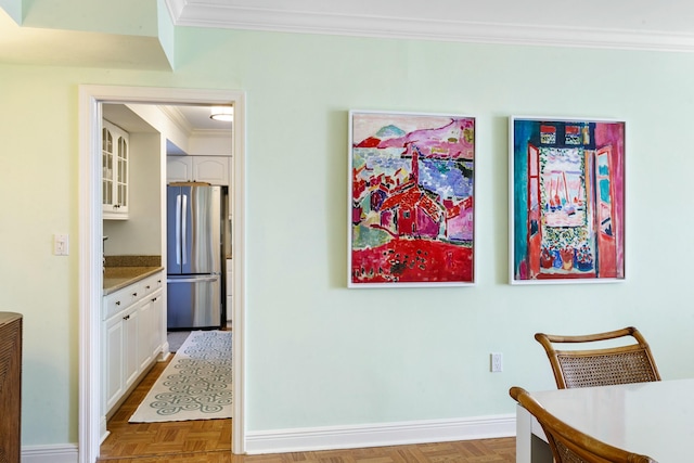 dining space with parquet flooring and crown molding