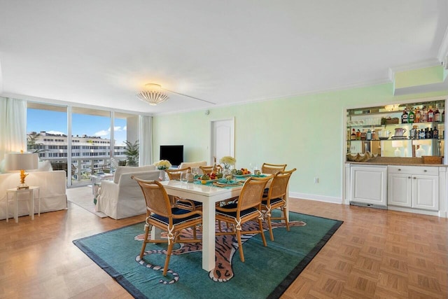 dining space featuring light parquet floors, a wall of windows, and crown molding