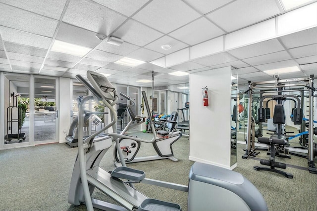 exercise room featuring carpet and a paneled ceiling