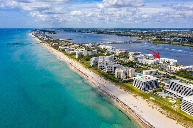 birds eye view of property with a water view and a beach view